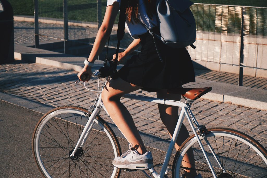 Legs of a young woman riding a bike in the city